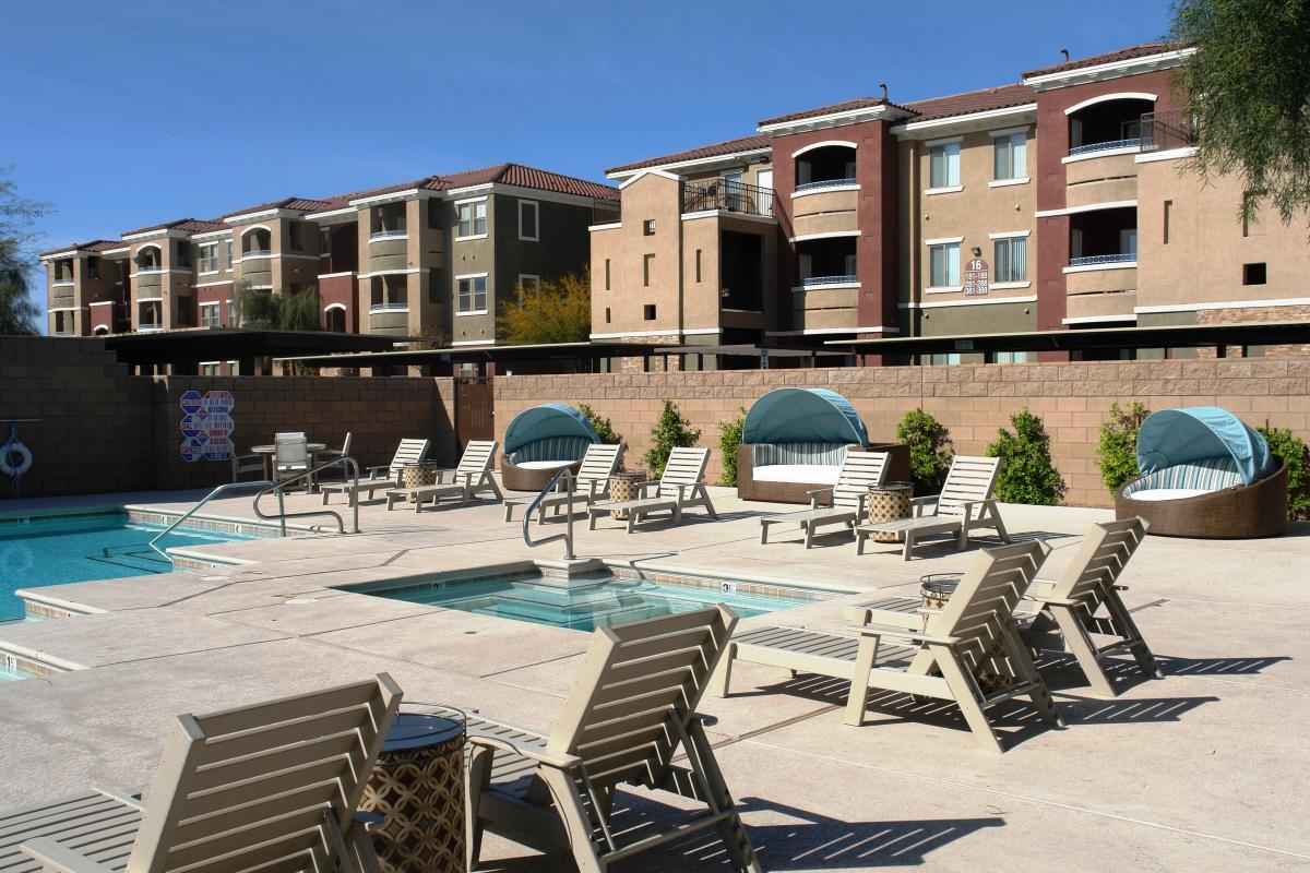 Community Pool With Jacuzzi And Sun Chairs